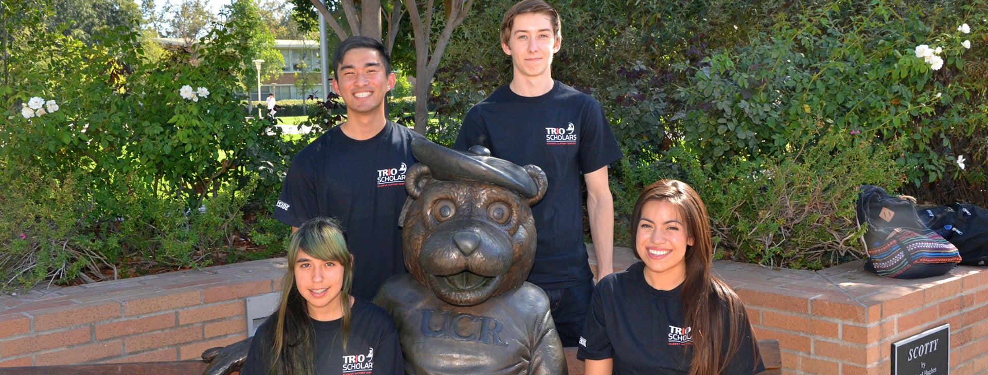 Four TRIO Scholars students pose near a sculpture of UCR's mascot, Scotty.